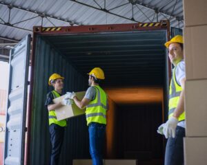 Blue collar workers are working at warehouse.