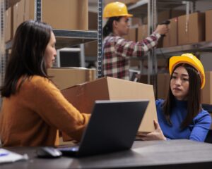 Storehouse employees checking box packaging quality and managing shipment